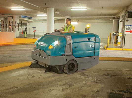 Picture of the Tennant s30 ride on sweeper doing the rounds in a car park